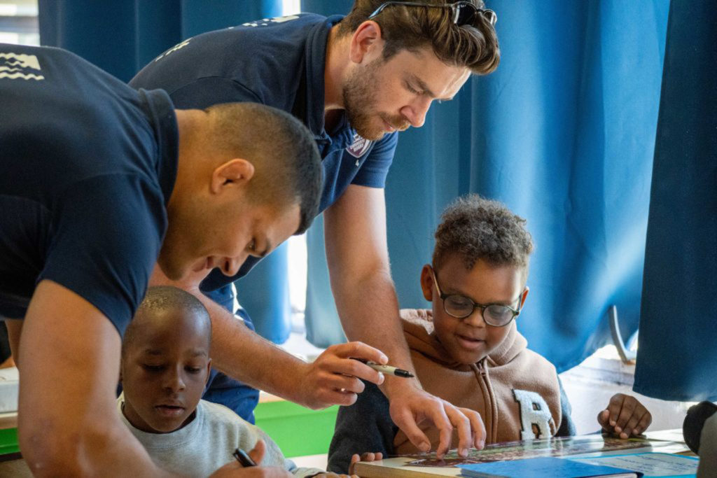 Adultes enseignant à deux enfants.