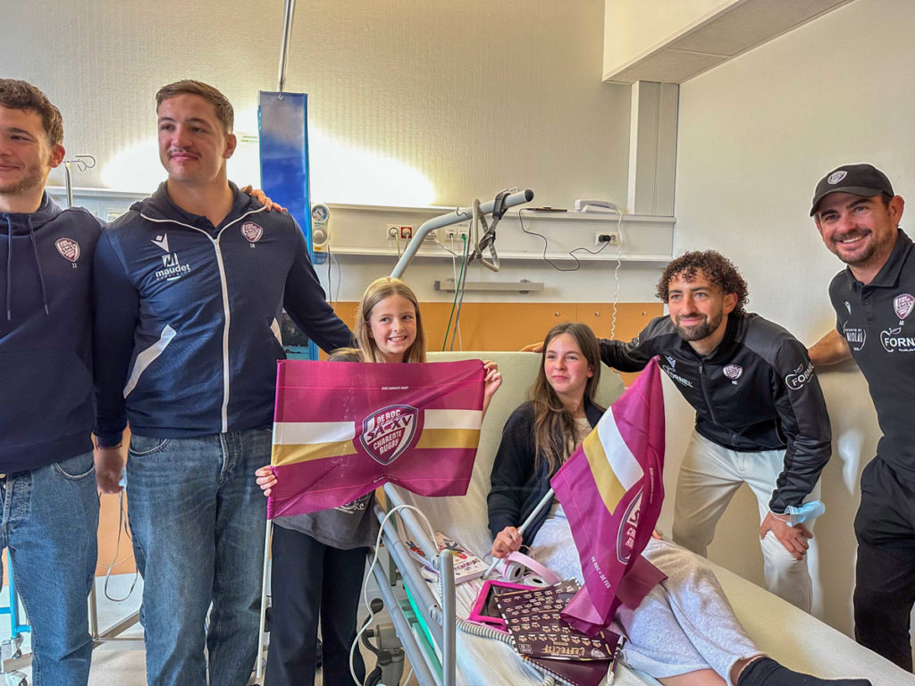 Visite d'hôpital avec des joueurs de rugby.